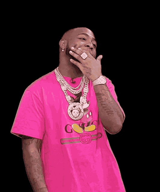 a man wearing a pink shirt that says gucci