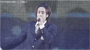 a man in a suit singing into a microphone