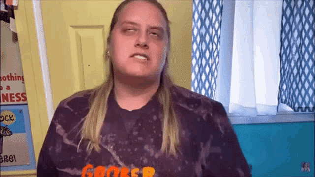 a woman wearing a purple shirt with the letter r on it