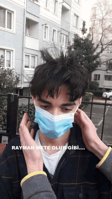 a man wearing a blue face mask with the words rayman mete olur gibi written below him