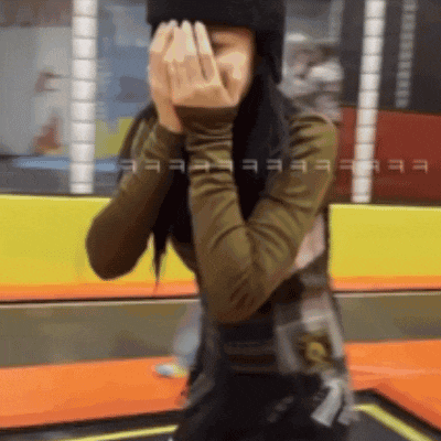a woman covering her face with her hands in a blurred photo