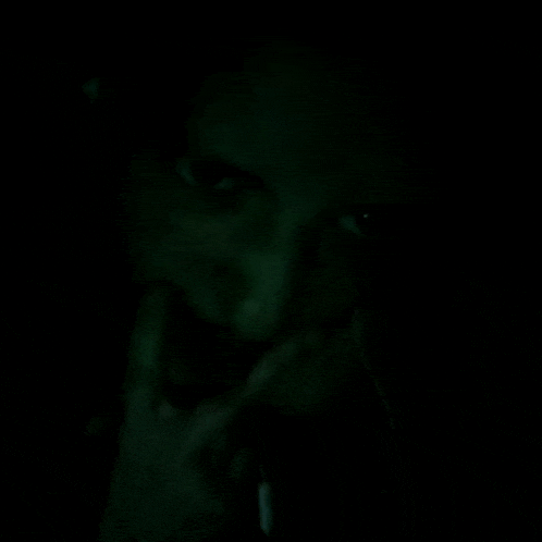 a close up of a person 's face in a dark room