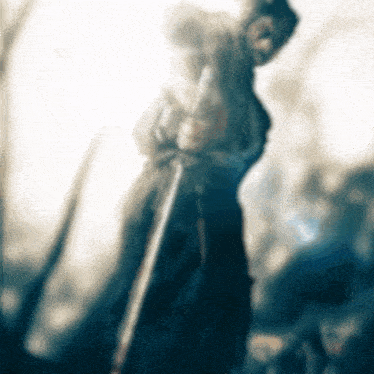 a blurred image of a man holding a sword