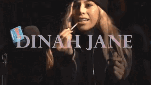 a woman wearing a black hat and a black jacket with the name dinah jane on it
