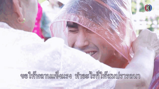 a man with a plastic bag on his head is being hugged by another man