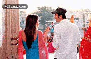 a man and a woman are standing next to each other . the woman is smoking a cigarette .