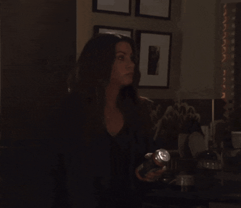 a woman is holding a flashlight in her hand in a dark room