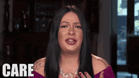 a woman wearing a necklace and a purple top says care