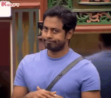 a man with a beard is wearing a blue t-shirt and a black shoulder strap .