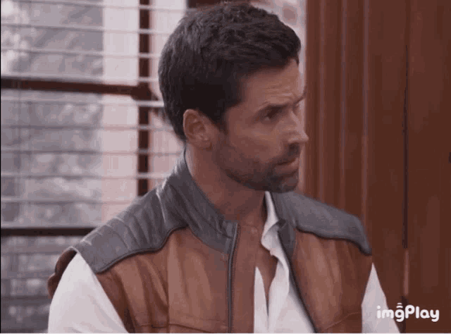 a man wearing a brown leather vest and a white shirt with imgplay written on the bottom right