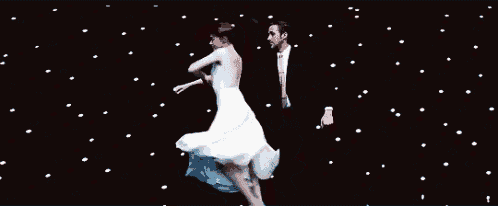 a man and a woman are dancing on a stage .