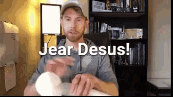 a man sitting in front of a bookshelf with the words jear desus written above him