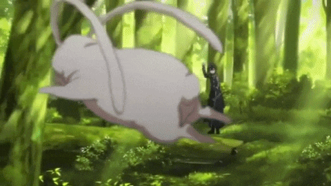 a person is standing next to a large white animal in the woods .