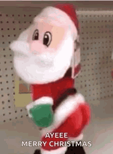 a stuffed santa claus is standing in a store holding a cup of coffee and saying `` merry christmas '' .