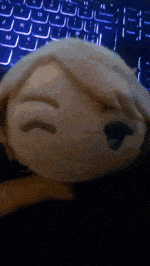 a stuffed animal is making a funny face in front of a laptop keyboard