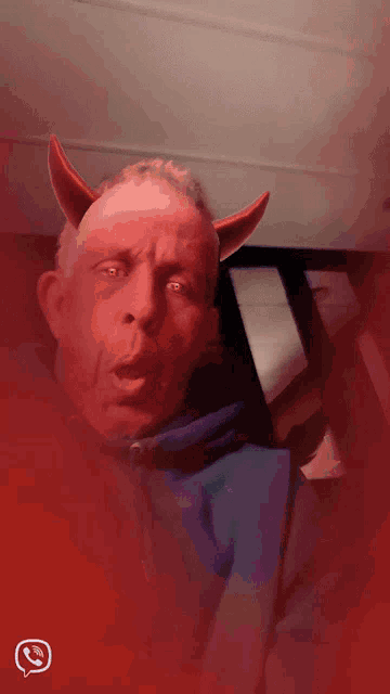 a man with red horns and a whatsapp logo on the bottom right