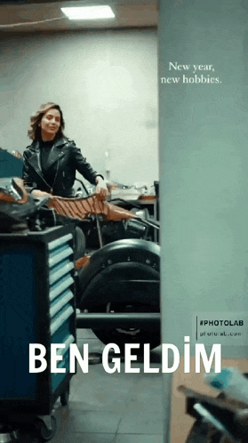 a woman in a leather jacket is standing in a garage with the words ben geldim below her