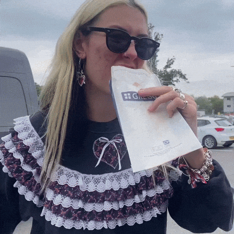 a woman wearing sunglasses is biting into a bag that says grouse