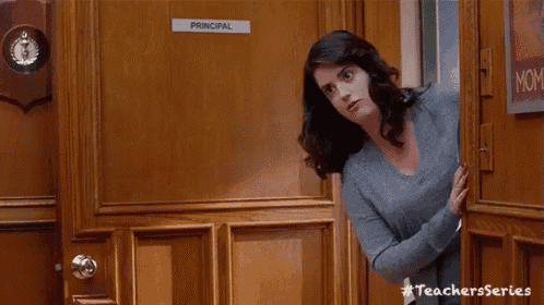 a woman stands in front of a door that says principal