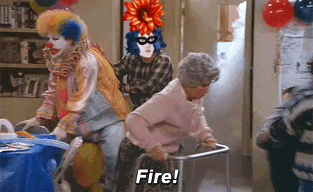a woman with a walker is being pushed by two clowns and says fire