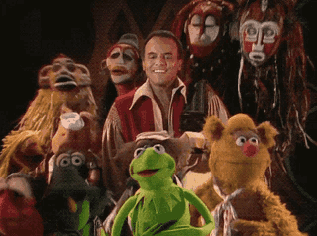 a group of muppets including kermit and fozzie bear pose for a picture