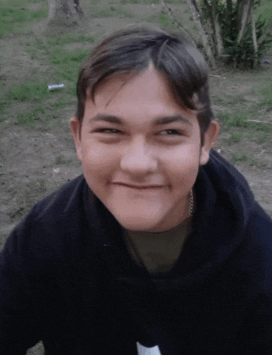 a young man wearing a black hoodie looks at the camera