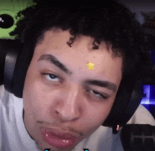 a man wearing headphones is making a funny face while looking at the camera .