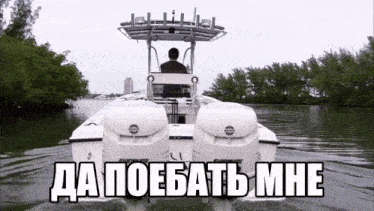 a man is driving a boat on a lake with russian writing on it