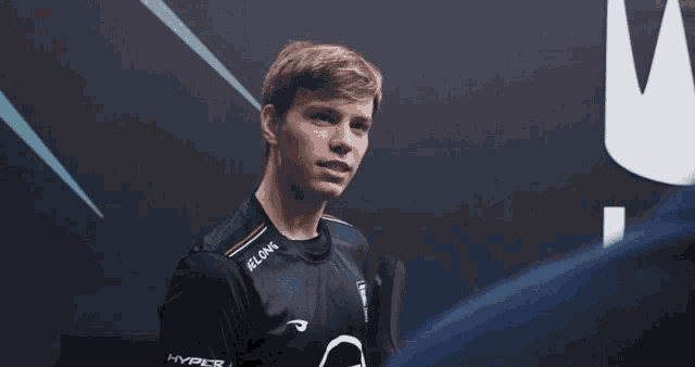 a man wearing a hyperx shirt looks to the side