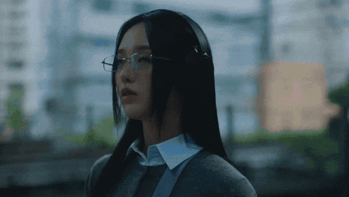 a woman with long black hair wearing glasses
