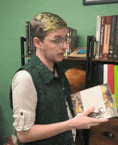 a man in a green vest is holding a book that says " core rulebook "
