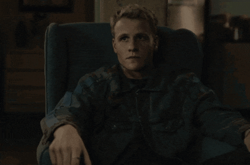 a man sitting in a chair with a ring on his finger