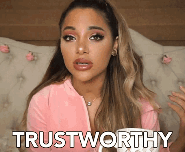 a woman sitting on a couch with a cup of coffee and the word trustworthy written on her face