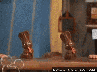 a boy is eating chocolate bunny rabbits with a disney channel logo behind him