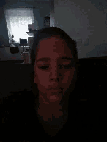 a person 's face is visible in a dark room