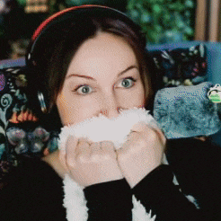 a woman wearing headphones is holding a stuffed animal in front of her mouth