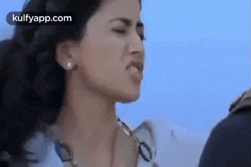 a woman is making a funny face with her mouth open .