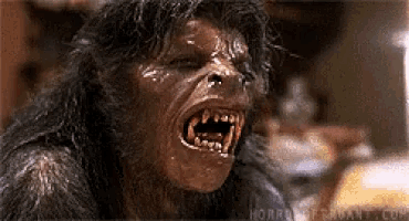 a close up of a werewolf 's face with its mouth open .