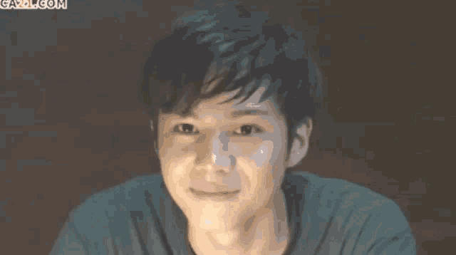 a close up of a young man 's face with the website gazz.com in the background
