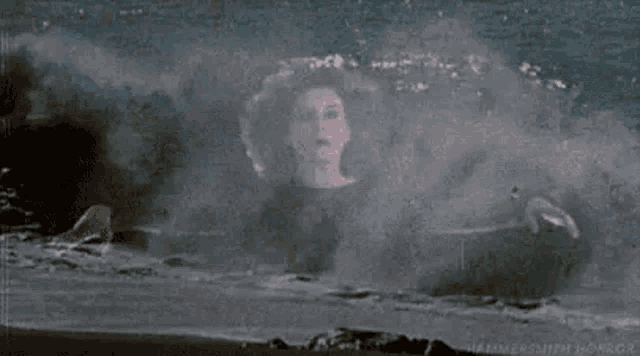 a woman is swimming in the ocean with waves crashing on her .