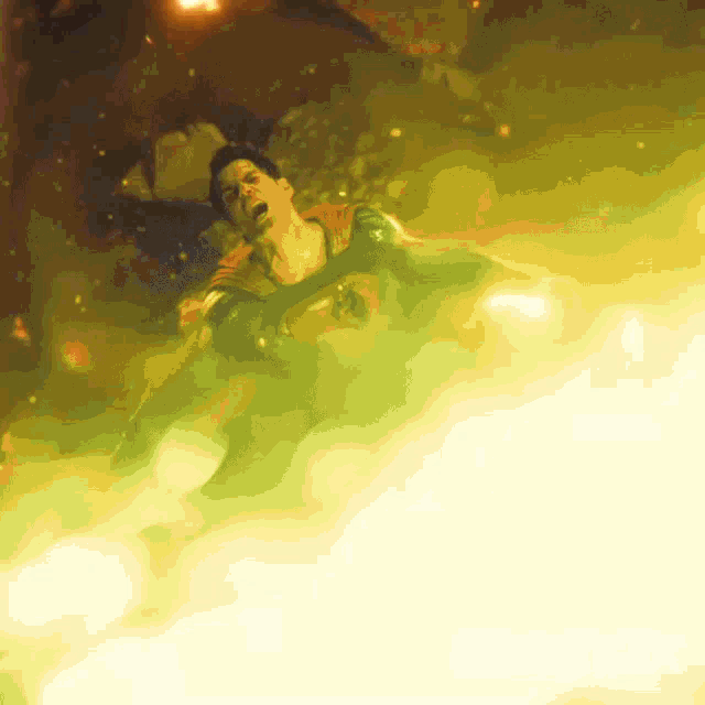 a man in a superhero costume is surrounded by a green and yellow light