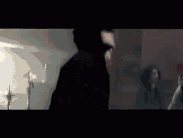 a blurry picture of a man standing in front of a drum set in a dark room