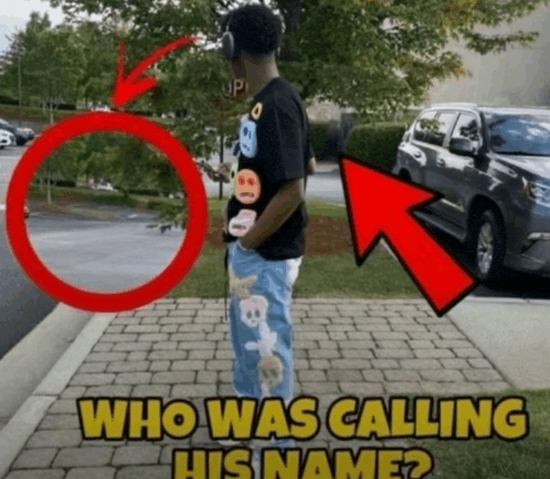 a man wearing headphones is standing on a sidewalk next to a stop sign