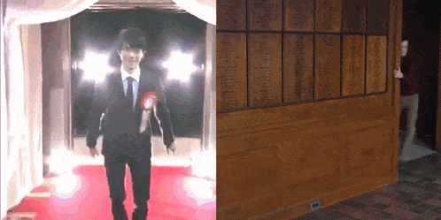 a man in a suit and tie walks down a red carpet