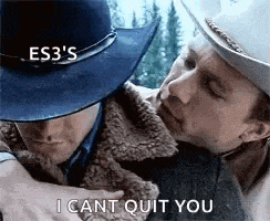 a man in a cowboy hat is hugging another man .