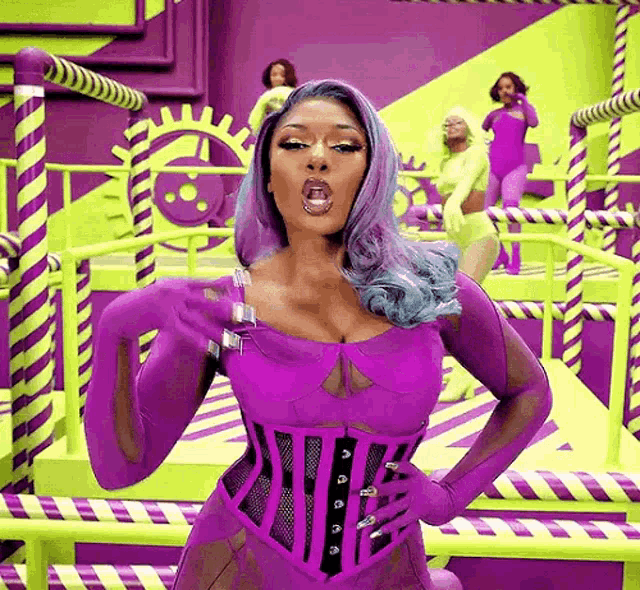 a woman in a purple corset and gloves is standing in front of a candy factory .