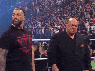 two men are standing in a boxing ring with one wearing a shirt that says ' tna '