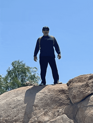 a man standing on top of a rock wearing a black shirt that says ' abercrombie & fitch '