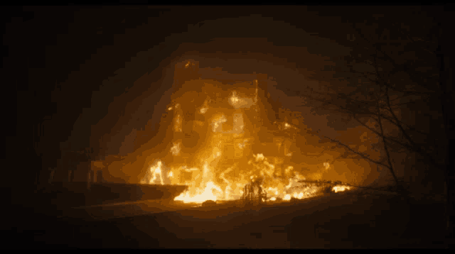 a large building is on fire at night with a lot of flames coming out of it