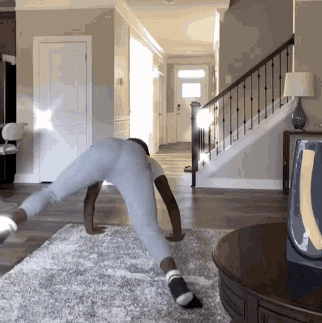a person doing a handstand in a living room